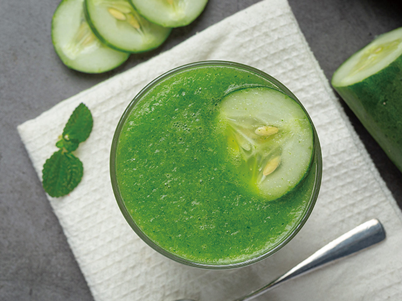 Glass of fresh cucumber juice on dark background